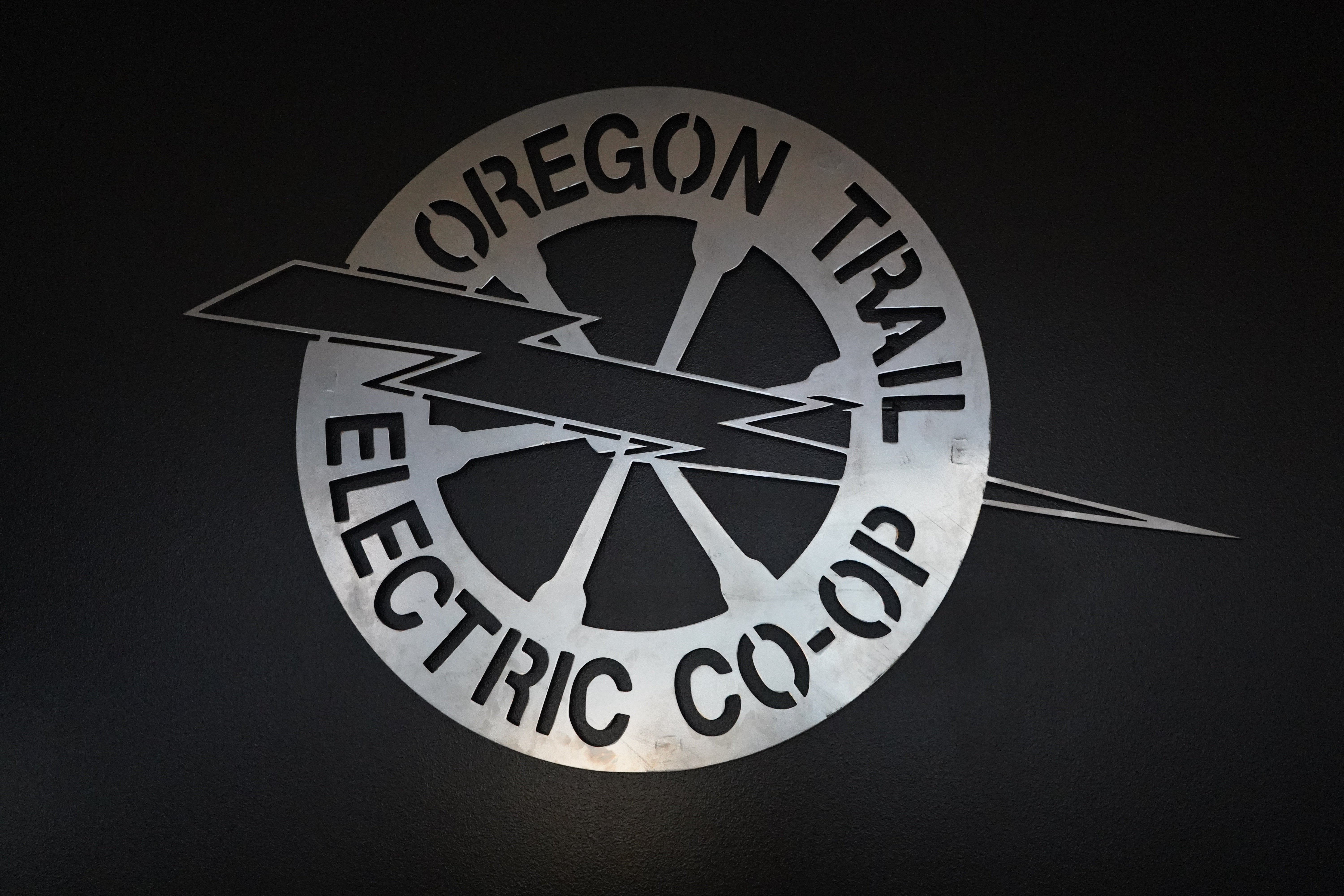 Silver OTEC logo on black background